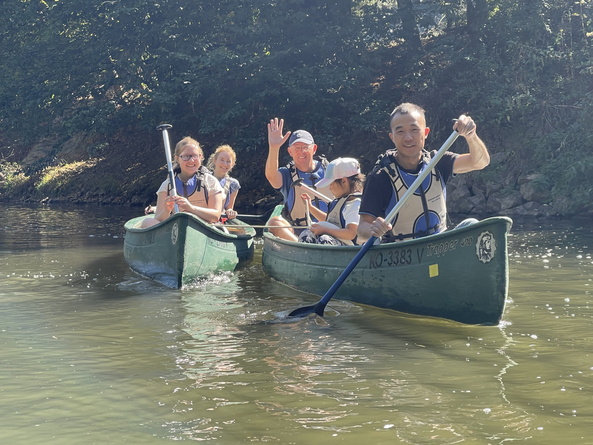 Personen sitzen in einem Kanu und fahren auf einem Fluss