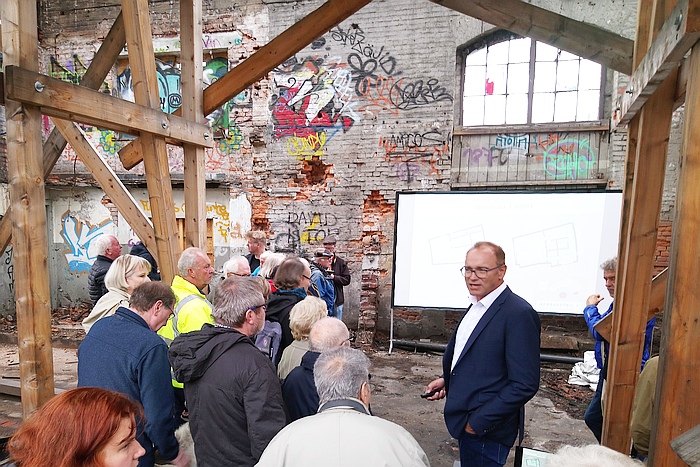 Gunter Schneider, Geschäftsführer der Schneider Optikmaschinen aus Fronhausen, informierte über das Konzept zur Revitalisierung des Industriedenkmals und ermöglichte zusammen mit dem Architekt Bernward Paulick einen Blick hinter die Kulissen der Baustelle (Foto: Hörster)